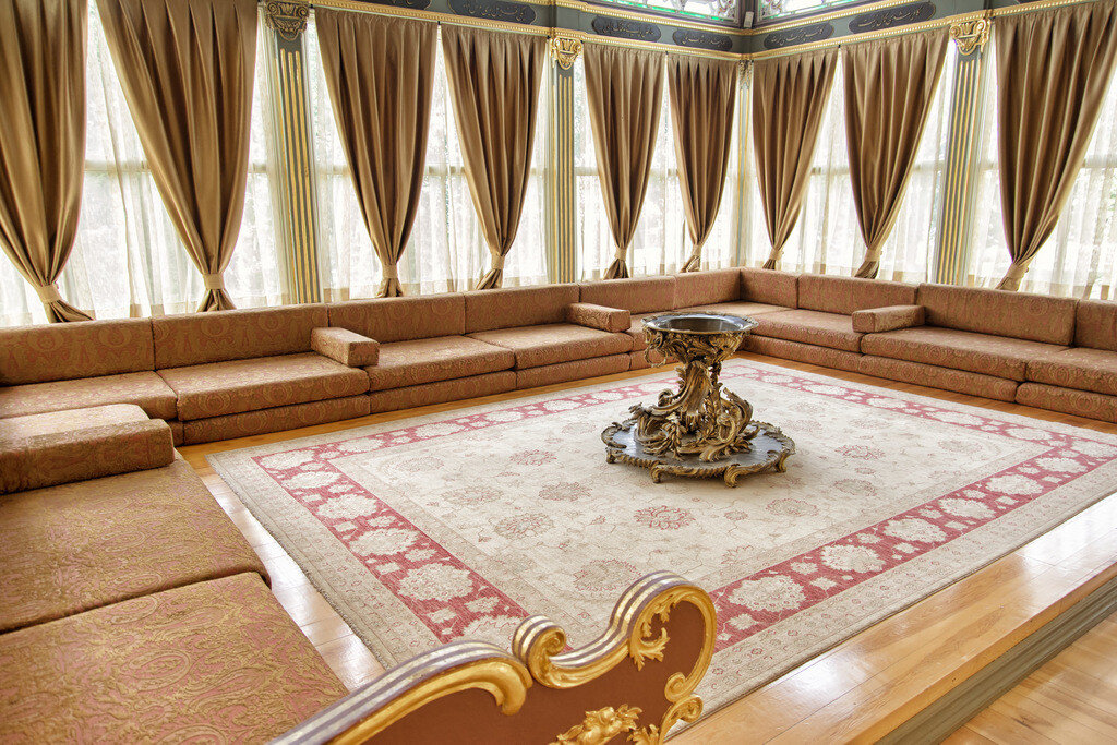 A large Oushak (Uşak) carpet displayed inside the Sofa Pavilion (Kara Mustafa Paşa Köşkü) at Topkapı Palace, illustrating the scale, soft color palette, and medallion-based design typical of classical Ottoman-era carpets